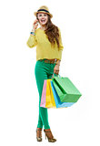 Woman with shopping bags talking smartphone on white background