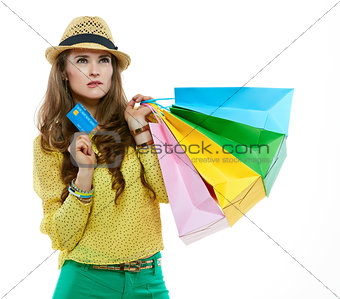 Portrait of thoughtful woman with shopping bags and credit card