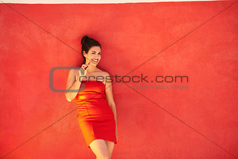 Girl Smiles Electronic Cigarette E-Cig Leaning On Red Background
