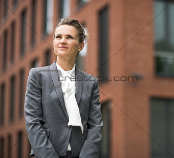 Portrait of happy modern business woman against office building