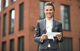 Smiling business woman using tablet PC against office building