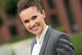 Portrait of smiling modern business woman near office building