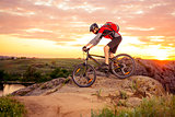 Cyclist Riding the Bike on the Mountain Rocky Trail at Sunset