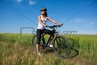 girl rides a bicycle in the countryside