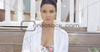 Smiling woman in swimsuit sitting near fence