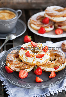 Cream puff rings decorated with fresh strawberry and caramel sau