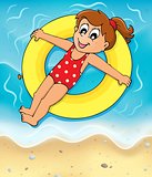 Girl on swim ring at seashore