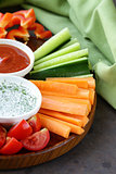 fresh vegetables snack - carrots, sweet pepper, cucumbers and tomatoes with dip
