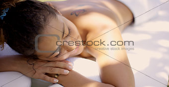 Woman on massage table at outdoor spa
