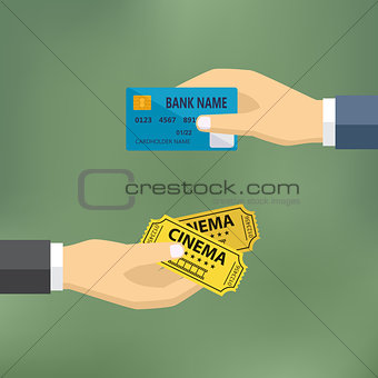 Hands with credit card and cinema tickets.