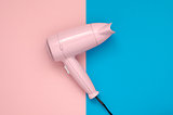 Pink hair dryer on pink and blue background