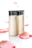 Two blank cosmetic bottles on rose's petals