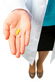 yellow pills on the palm of the doctor