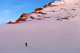 Hiker in sunrise snowy mountains