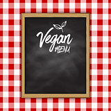 Vegan menu chalkboard on a checked cloth background