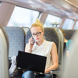 Business woman working while travelling by train.