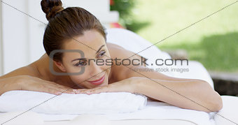 Woman on table with hair up in a bun smiles