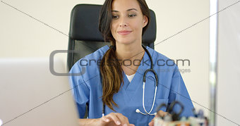 Beautiful female doctor at laptop computer