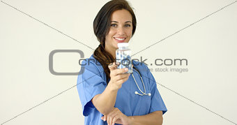 Young brown haired doctor in scrubs holds bottle