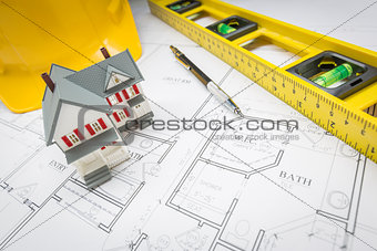 Home, Level, Hard Hat and Pencil Resting on House Plans
