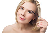 Beautiful middle aged woman applying eyebrow gel