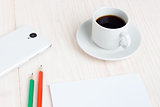 Cup of coffee, a Notepad, pencils, a smartphone on the table