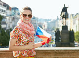 Woman with Czech flag standing at Wenceslas Square in Prague