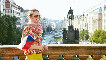 Woman with Czech flag standing near National Museum in Prague