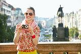 Woman with digital camera standing near National Museum, Prague