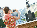 Seen from behind woman taking photos with camera in Prague