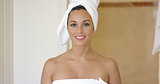 Smiling brunette wearing white towel on head