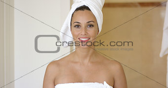Smiling brunette wearing white towel on head