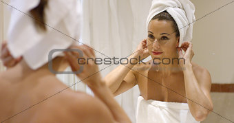 Gorgeous young woman wrapping her hair in a towel