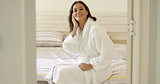 Gorgeous woman in robe sitting on bed