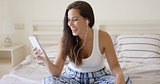 Happy woman listening with ear buds and tablet