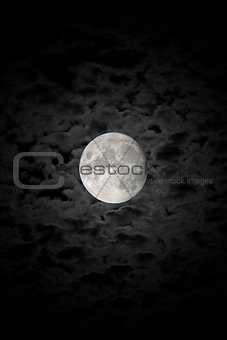 The detailed moon in background of the cloudy night sky