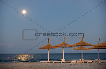Parasol on a beach and moon