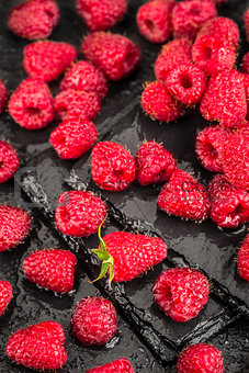 Fresh red raspberries on a slate background