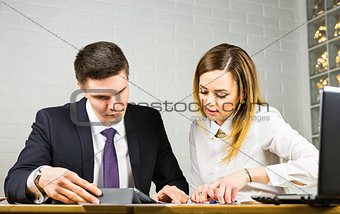Businesspeople With Digital Tablet Sitting In Modern Office
