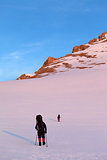 Two hikers in sunrise snowy plateau