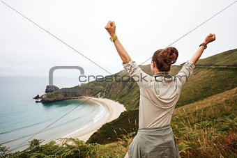 healthy woman rejoicing in front of ocean view landscape