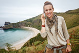 woman hiker talking on mobile in front of ocean view landscape