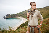 woman hiker with camera in front of ocean view landscape