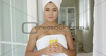 Beautiful woman wrapped in towel looking outside