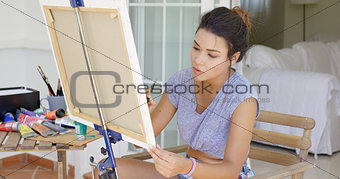 Attractive female artist working on a canvas