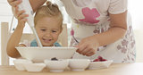Cute happy little girl helping with the baking