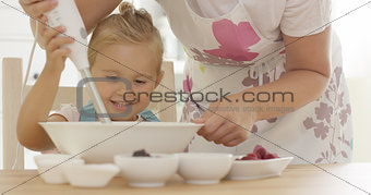 Cute happy little girl helping with the baking