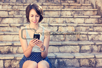 Young Hipster Girl Texting with Her Mobile Phone