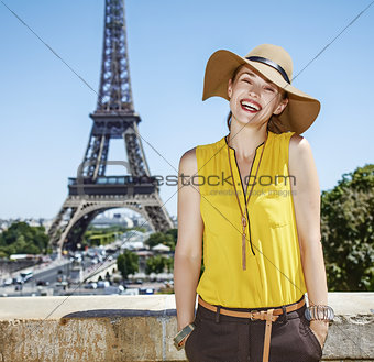 happy young woman in bright blouse against Eiffel tower in Paris
