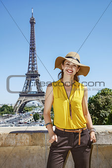 smiling woman in bright blouse in front of Eiffel tower in Paris